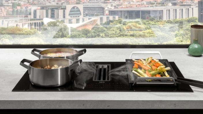 Placa de inducción con extractor en una cocina con vistas a la ciudad