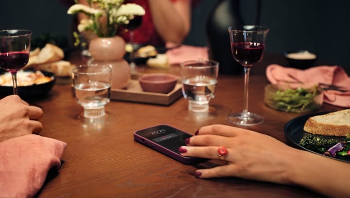 Personas sentadas alrededor de una mesa con comida y bebida. 