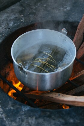 Recipiente con agua hirviendo en una hoguera