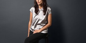 Mujer con blusa de seda plateada recién lavada