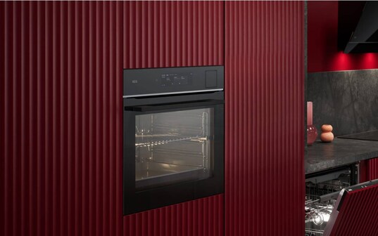 An oven in a red kitchen.
