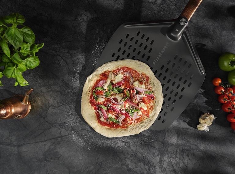 Recogiendo una pizza con una pala para pizza.