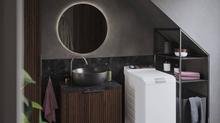 Lavadora AEG de carga superior en un baño.