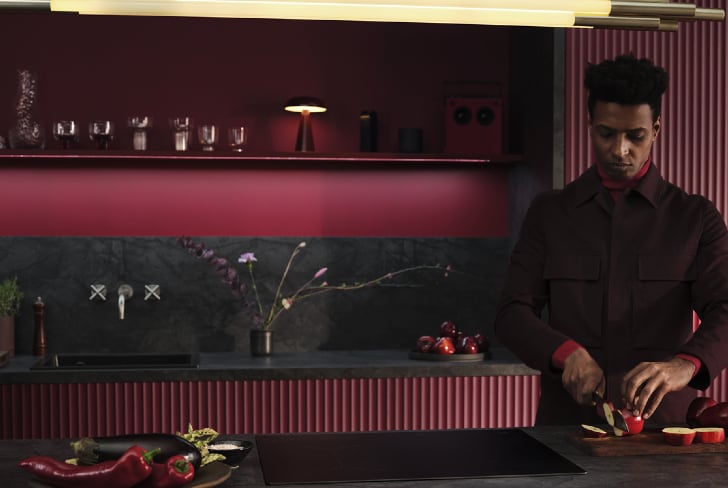 Hombre cortando fruta en una cocina.