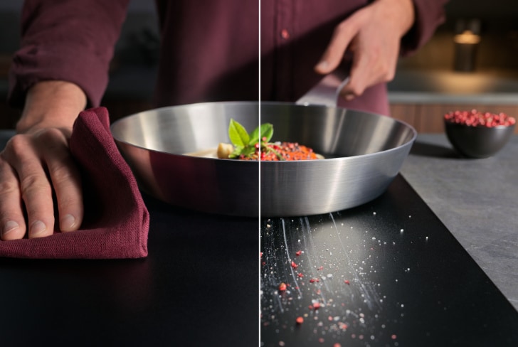 Manos cocinando y limpiando en una placa de inducción.